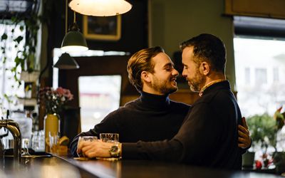 Two gay men gaze passionately into each other's eyes, about to exchange a kiss 