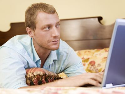 Man on his laptop in the bedroom