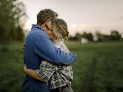 Couple hugging in a field at dusk