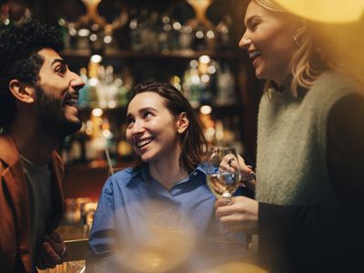 3 friends talking at a bar