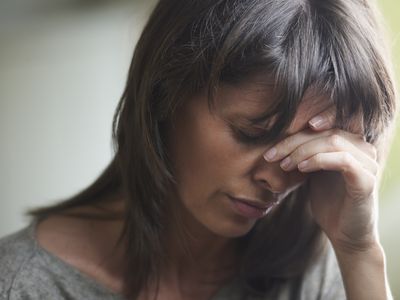 Mature woman with head in hands