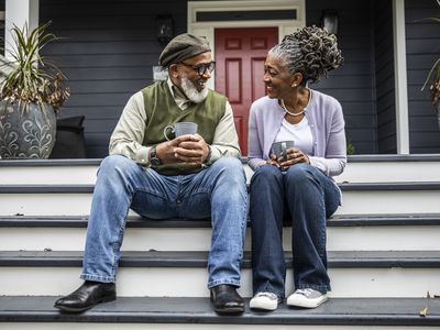 Senior couple having coffee in front of suburban home