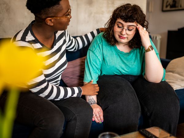 Two women are sitting in the living room talking