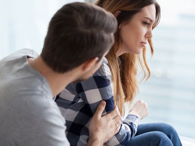 Caring man comforting upset wife after fight