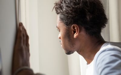 anxious man looking out window