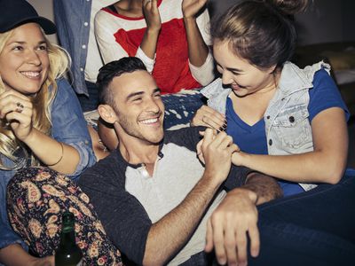 Man at a party with women around him