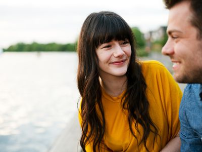 Woman looking at man, smiling. Both of them enjoying hanging out with each other