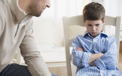 Father looking at upset young boy