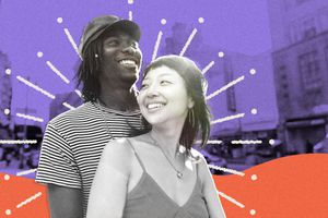 A happy young couple from the chest up smiling with a city street in the background