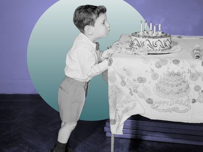 Little boy blowing out candles on birthday cake