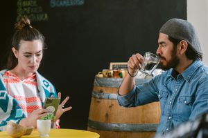 Modern marriage enjoying together having a coffee cup and using smartphone at cosy cafeteria