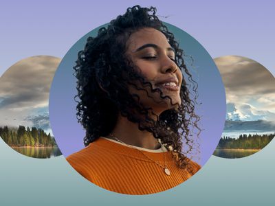 Woman smiling with eyes closed meditating against a mountain backdrop