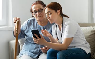 Senior woman with nurse at home