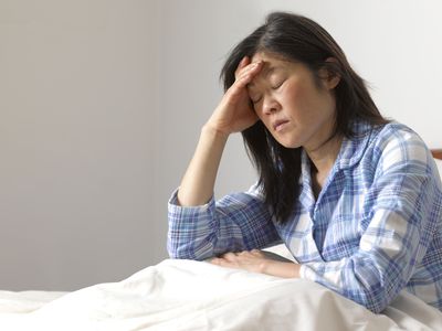 Woman with headache in bed