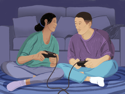 A couple sitting on living room rug, gaming together